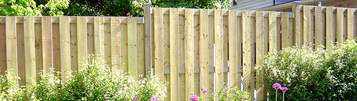 A newly constructed fence with landscaping in front.